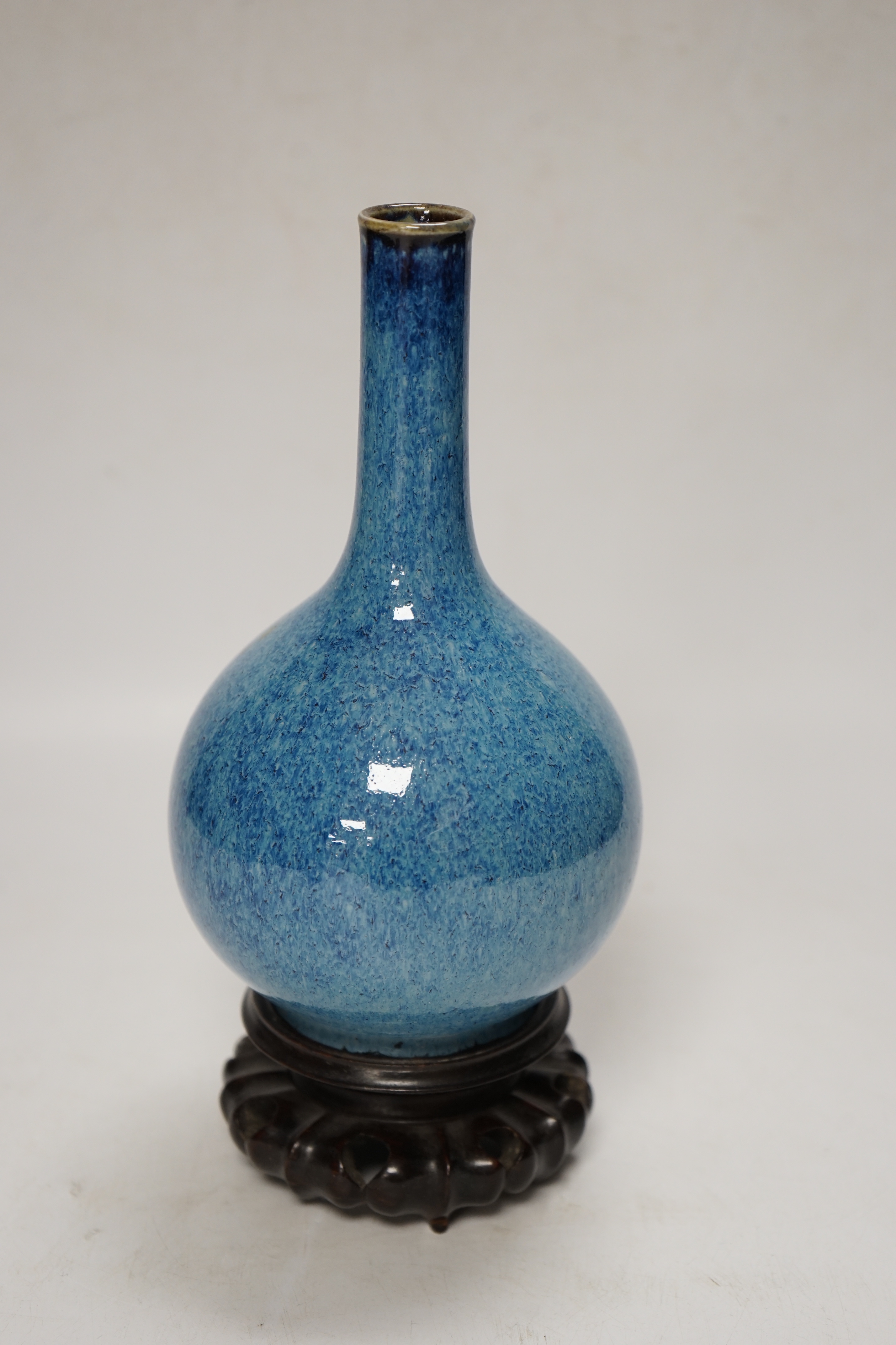 A Chinese blue flambe bottle vase, on stand, 22cm
